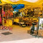 Vibrant stalls and handicraft shops at Dilli Haat displaying traditional Indian textiles, jewelry, and handicrafts